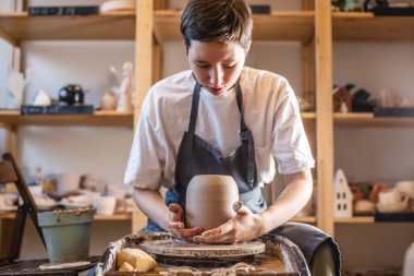 Potter 's Wheel' de vazo yapan kadın çömlekçi. Usta sürahiyi çemberden çekip nazikçe elinde tutuyor.