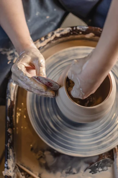 O Potter a trabalhar na roda de um Potter a fazer um vaso. Mulher formando o barro com as mãos criando jarro em uma oficina. Vista superior — Fotografia de Stock