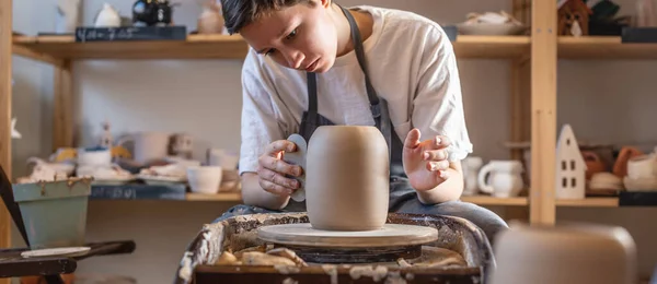 Potter arbetar på en Potter hjul gör en vas. Master bearbeta den bildade kannan ger den rätt form — Stockfoto
