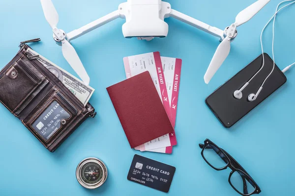 度假时飞行所必需的东西 银行卡 无人机 蓝色背景的相机 方便旅行准备的概念 顶部视图 — 图库照片