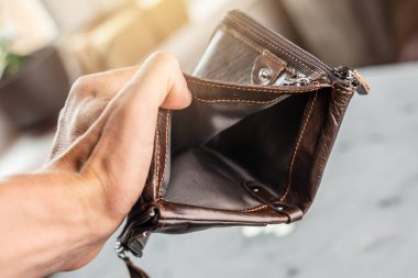 Adamın elinde açık kahverengi deri bir cüzdan var. Salgın sonrası ekonomik kriz ve iş iflası kavramı