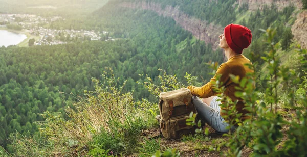Tourist Traveler Backpack Red Hat Sitting Edge Cliff Looking Green — Stock Photo, Image