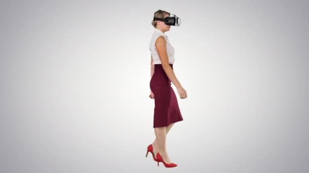 Jonge vrouw dragen virtual reality apparaat en lopen op gradiënt achtergrond. — Stockvideo