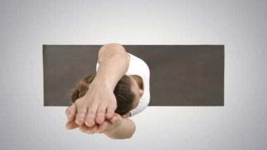 Güzel genç kadın ayak bileği, buzağı, uyluk, kalça ve omuzlar, Eagle Pose, Garudasana degrade arka planda Yoga egzersiz yapıyor.