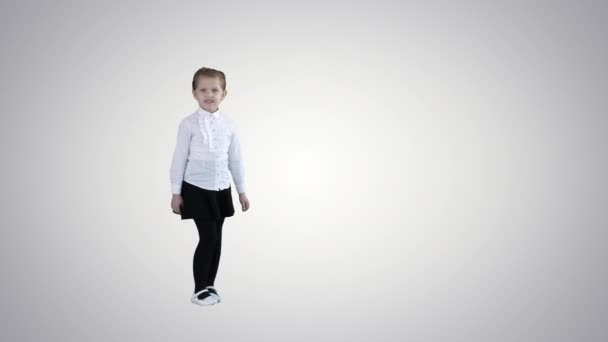 Милая маленькая девочка улыбается и уверенно разговаривает с камерой на градиентном фоне . — стоковое видео
