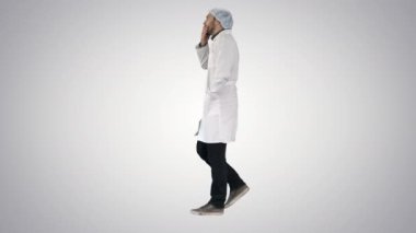 Eğilimli arka planda yürüyen düşünceli erkek doktor..