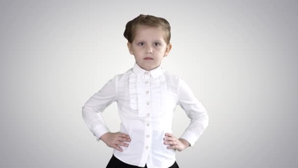 Маленька мила дівчинка ходить руками на стегнах на градієнтному фоні . — стокове відео