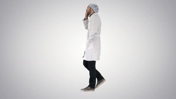 Médico masculino reflexivo que camina sobre fondo del gradiente. — Vídeo de stock
