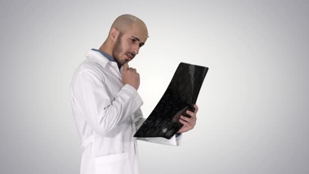 Joven médico varón leyendo y revisando una resonancia magnética cerebral mientras camina sobre el fondo del gradiente . — Vídeos de Stock