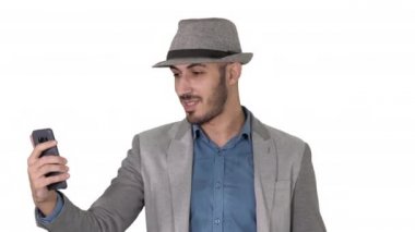 Günlük giysiler içinde çekici bir adam. Hipster stilisti video bloğu hazırlıyor. Ya da beyaz arka planda bir video görüşmesi yapıyor..