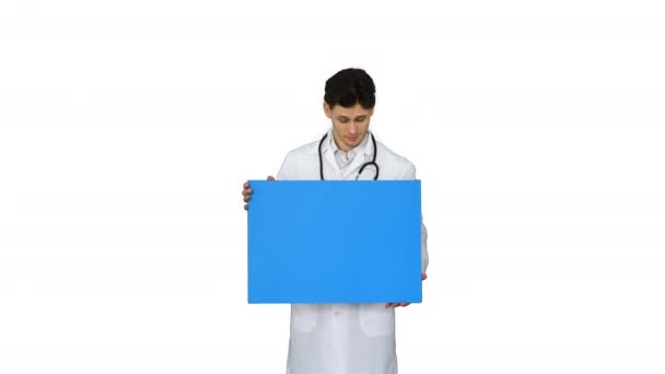 Médico sorridente vestindo um estetoscópio segurando cartaz em branco no fundo branco . — Vídeo de Stock