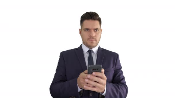 Searching for an answer Good looking businessman using his smart phone thinking on what to answer on white background. — Stockvideo