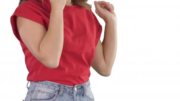 Femme en t-shirt rouge faisant des gestes tout en parlant au téléphone sur fond blanc. — Video