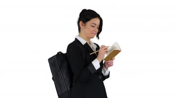 Pretty student with backpack writing notes on white background. — Stock Video