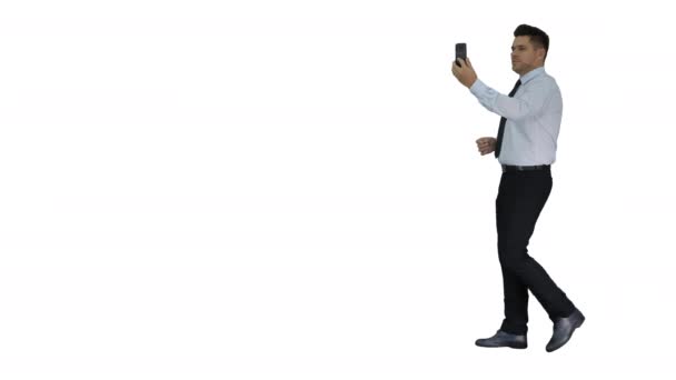 Happy young handsome businessman recording vlog or making video call on white background. — Stockvideo