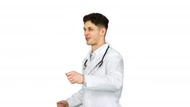 Jovem médico vestindo jaleco dançando no fundo branco . — Vídeo de Stock