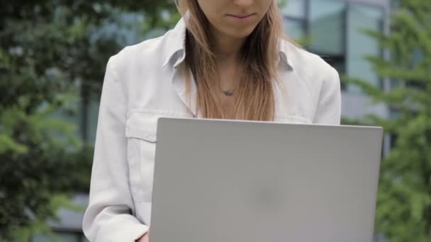 Привлекательная молодая женщина с ноутбуком снаружи — стоковое видео