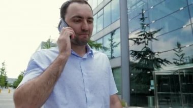 Çekici iş adamı cep telefonuyla konuşuyor, mutlu hissediyor, iyi haberler duyuyor..