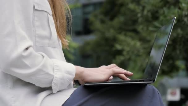 Kobieta pracuje na laptopie na zewnątrz. — Wideo stockowe