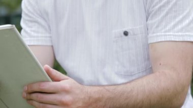 Modern dijital tablet disarida bir adam ekrana dokunuyor..