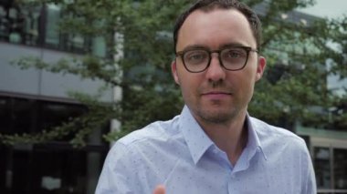 Gülümseyen yakışıklı genç adam kameraya bakarak müzikten zevk alıyor..