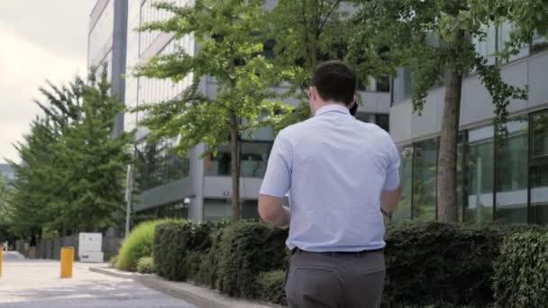 Hombre en el teléfono - joven hombre de negocios caminando con teléfono inteligente en traje casual inteligente . — Vídeo de stock