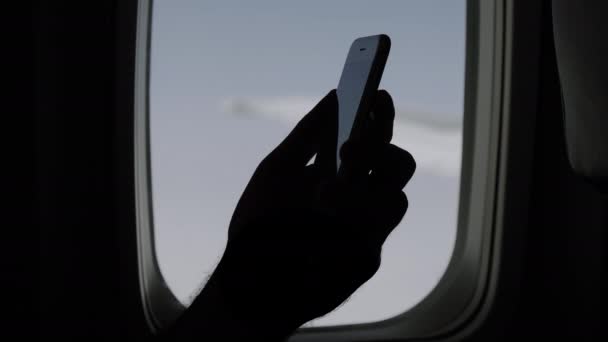 Mans hand houden en het gebruik van mobiele smartphone in het vliegtuig. — Stockvideo