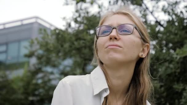 Красива молода бізнес-леді на відкритому повітрі думає, дивлячись навколо . — стокове відео