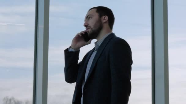 Επιχειρηματίας μιλάει στο τηλέφωνο περιμένοντας την πτήση. — Αρχείο Βίντεο