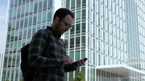 Joven guapo inteligente Casual Hombre Revisando correos electrónicos en su Smartphone . — Vídeos de Stock