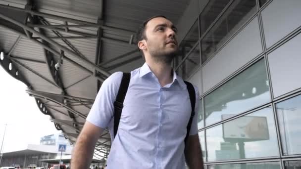 Homem procurando o terminal certo fora do aeroporto . — Vídeo de Stock