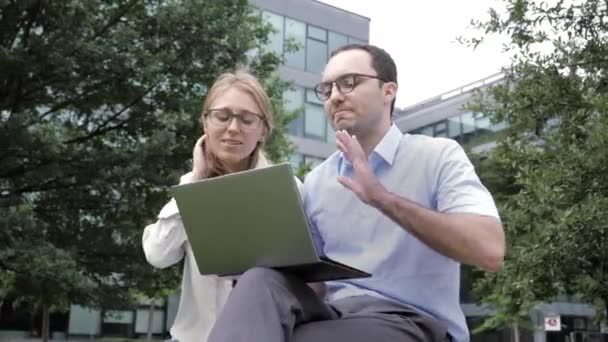 Sonriendo feliz pareja con ordenador portátil que tiene videollamada al aire libre . — Vídeos de Stock