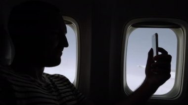 Gülümseyen adam uçakta selfie çekiyor..