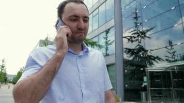Çekici iş adamı cep telefonuyla konuşuyor, mutlu hissediyor, iyi haberler duyuyor..