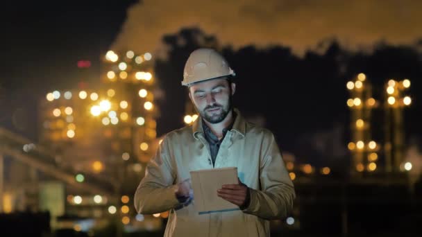 Young Caucasian engineer in hard hat using tablet swiping and looking to camera. — 비디오