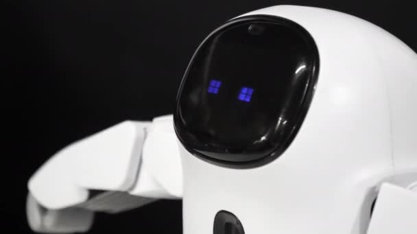 Pequeño robot de juguete de control remoto con ojos parpadeantes azules mueve las manos y el cuerpo . — Vídeo de stock