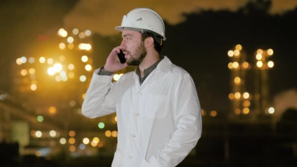 Ingenieur belt telefoon op chemische fabriek. — Stockvideo