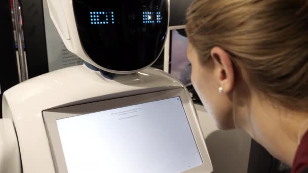 Robot umanoide con display touchscreen faccia parlare con la donna . — Video Stock