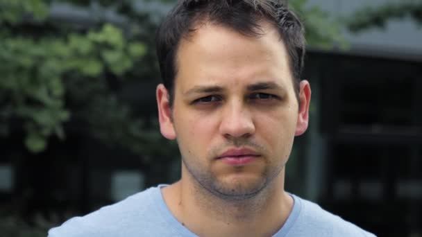 Handsome young man looking thoughtful pensive looking to camera. — Stock Video