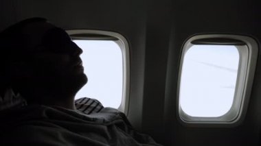 Man relaxing in sleeping mask in the airplane.