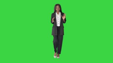 Genç Afrikalı iş kadını yeşil ekranda yürüyor ve konuşuyor, Chroma Key.