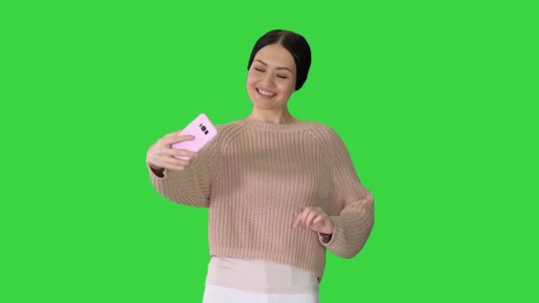 Nenucená brunetka dívka s úsměvem dělat selfie na telefonu na zelené obrazovce, Chroma Key. — Stock video