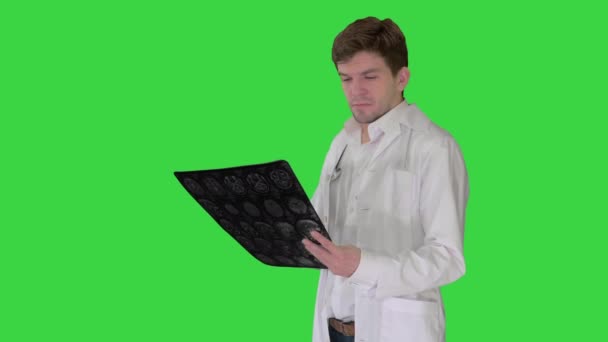 男医生看着X光MRI图像，看着摄像机，很不高兴，我们在绿色屏幕上做不到什么。. — 图库视频影像