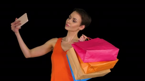 Attractive young woman holding different blank shopping bags making selfie, Alpha Channel — Stock Video