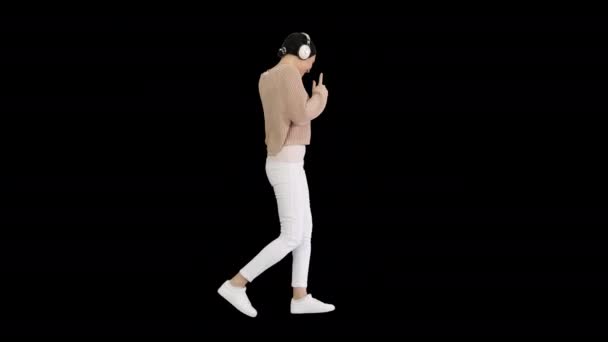Chica emocional feliz escuchando música a través de auriculares blancos y caminando, Alpha Channel — Vídeo de stock