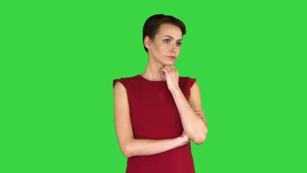 Attrayant jeune femme en robe rouge debout et écouter quelqu'un parler sur un écran vert, Chroma Key . — Video