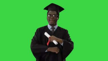 Genç Afrikalı Amerikalı adam yeşil ekranda yürürken ve telefon kullanırken, Chroma Key.