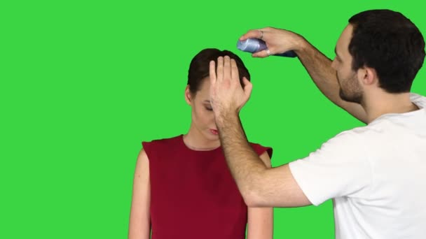 Schoonheid, kapsel en mensen concept - jonge vrouw met kapper met haarlak op een groen scherm, Chroma Key. — Stockvideo