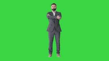Beyaz gömlekli, elleri yeşil ekranda katlanmış genç, kendine güvenen bir adam, Chroma Key.