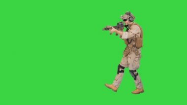 Asker tüfekle yürüyor ve telsizi yeşil ekranda kullanıyor, Chroma Key.
